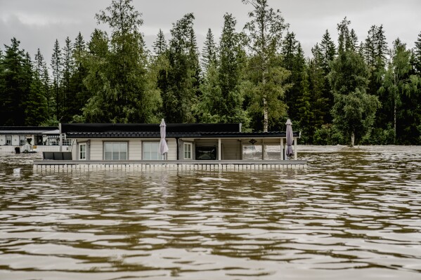 Parts of a camping area are completely flooded with water after the Dokka River has overflowed its banks in Dokka, Norway, Wednesday, Aug. 9, 2023. Storm Hans has battered parts of Scandinavia and the Baltics for several days, causing rivers to overflow, damaging roads and injuring people with falling branches. (Stian Lysberg Solum/NTB Scanpix via AP)