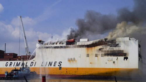 Emergency personnel battle against a fire aboard the Italian-flagged Grande Costa d'Avorio cargo ship at the Port of Newark, Friday, July 7, 2023, in Newark, N.J. The cargo ship burned for a third day Friday at the port after a fire that claimed the lives of two Newark firefighters Augusto "Augie" Acabou and Wayne "Bear" Brooks Jr. , and exposed gaps in the ability of fire crews to respond to emergencies on hulking container ships. (AP Photo/John Minchillo)