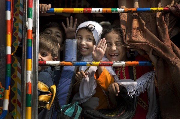 FILE - Children peek out of a bus as they leave school in Wajah Khiel, Swat Valley, Pakistan, Oct. 4, 2013. (AP Photo/Anja Niedringhaus, File)