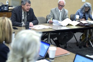 North Dakota Attorney General Wayne Stenehjem, left, speaks during a meeting of the state Pardon Advisory Board at the state penitentiary in Bismarck, North Dakota on Wednesday, July 10, 2019. Stenehjem proposed and the board members approved a shorter pardon application form or certain marijuana convictions. To the right is advisory board chairman H. Patrick Weir, and board member Carmelita Lamb.   (Mike McCleary/The Bismarck Tribune via AP)
