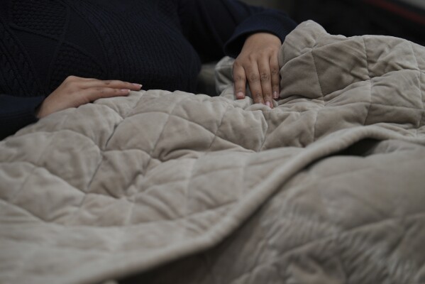 Weighted blankets on display in a Saatva mattress showroom in New York, Dec. 4, 2024. (AP Photo/Mary Conlon)
