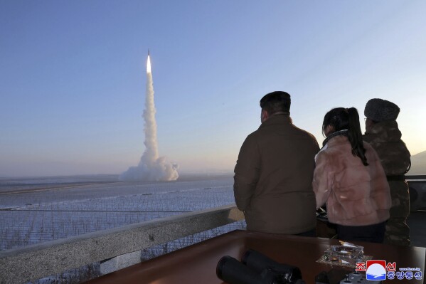 In this undated photo provided Monday, Dec. 18, 2023, by the North Korean government, North Korean leader Kim Jong Un, his daughter and an official watch what it says is an intercontinental ballistic missile launching from an undisclosed location in North Korea. Independent journalists were not given access to cover the event depicted in this image distributed by the North Korean government. The content of this image is as provided and cannot be independently verified. Korean language watermark on image as provided by source reads: 