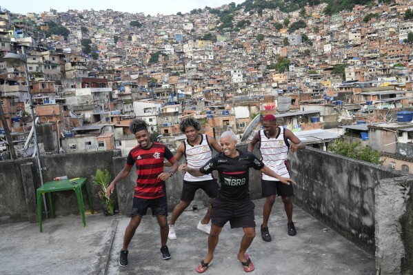Youth perform a street dance style known as passinho for their social media accounts, in the Rocinha favela of Rio de Janeiro, Brazil, Wednesday, April 17, 2024. The passinho, or “little step”, created in the 2000s by kids in Rio’s favelas, was declared an “intangible cultural heritage” by state legislators, bringing recognition to a cultural expression born in the sprawling working-class neighborhoods. (AP Photo/Silvia Izquierdo)
