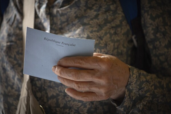 A voter casts a ballot at a polling station for the first round of the parliamentary elections in Paris, Sunday, June 30, 2024. (AP Photo/Aurelien Morissard)