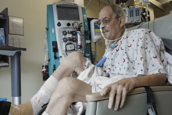 In this image from video provided by the University of Maryland School of Medicine, Lawrence Faucette, a pig heart transplant patient, works with a physical therapist at the school's hospital in Baltimore, Md., on Wednesday, Oct. 18, 2023. (Tom Jemski/University of Maryland School of Medicine via AP)