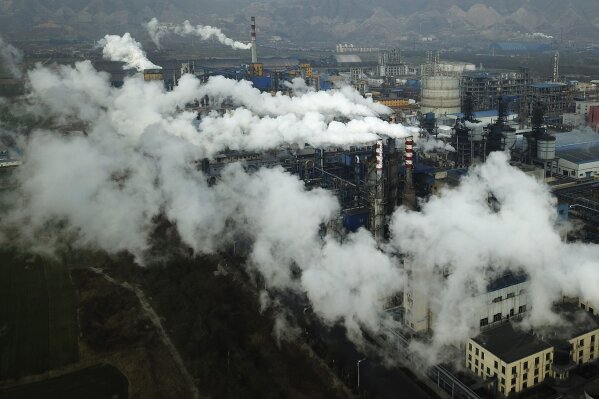 FILE - In this Nov. 28, 2019, file photo, smoke and steam rise from a coal processing plant in Hejin in central China's Shanxi Province. China's Premier Li Keqiang announced that the country would target a reduction of 18% in carbon intensity over the course of the next five years as part of the meeting of the ceremonial legislature which kicked off its annual meeting Friday, March 5, 2021. (AP Photo/Sam McNeil, File)