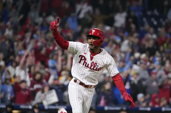 Philadelphia Phillies' Johan Rojas celebrates after hitting a game-winning run-scoring single in the 10th inning of a baseball game against the Pittsburgh Pirates to clinch a wild-card playoff spot, Tuesday, Sept. 26, 2023, in Philadelphia. (AP Photo/Matt Slocum)