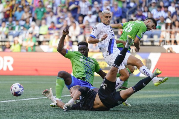 Seattle Sounders goalkeeper Stefan Cleveland (30) dives for the ball as Seattle Sounders defender Yeimar Gómez, left behind, Monterrey forward Germán Berterame and Seattle Sounders midfielder Alex Roldan (16) collide in the box during the first half of a Leagues Cup soccer match, Sunday, July 30, 2023, in Seattle. (AP Photo/Lindsey Wasson)