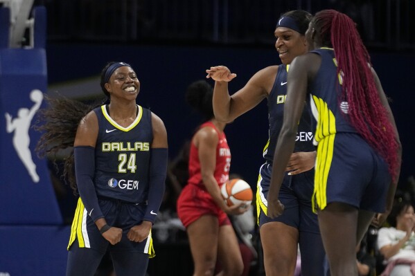 Dallas Wings' Arike Ogunbowale (24) Teaira McCowan, center, and Awak Kuier, right, celebrate after a basket by Ogunbowale in the first half of Game 2 of a first-round WNBA basketball playoff series against the Atlanta Dream, Tuesday, Sept. 19, 2023, in Arlington, Texas. (AP Photo/Tony Gutierrez)