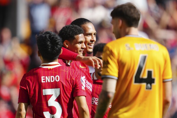 El jugador del Liverpool Jarrell Quansah, segundo desde la izquierda, celebra con sus compañeros después de anotar el segundo gol de su equipo durante el partido de fútbol de la Premier League entre Liverpool y Wolverhampton Wanderers en el estadio Anfield de Liverpool, Inglaterra, el domingo 19 de mayo de 2024. (AP Photo/John Soper)