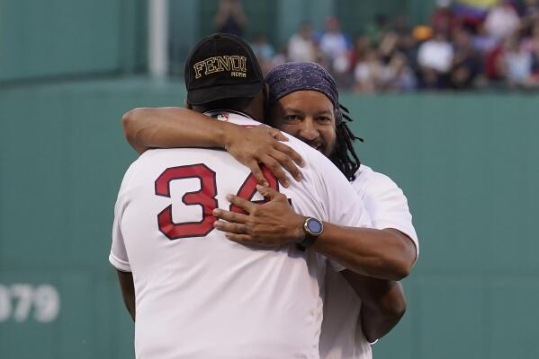 Former Boston Red Sox's Manny Ramirez, left, displays his Boston