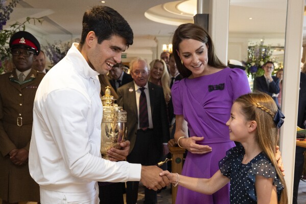 Carlos Alcaraz of Spain meets Princess Charlotte with Kate, Princess of Wales following his win in the men's singles final over Novak Djokovic at the Wimbledon tennis championships in London, Sunday, July 14, 2024. (Andrew Parsons/AELTC/Pool Photo via AP)
