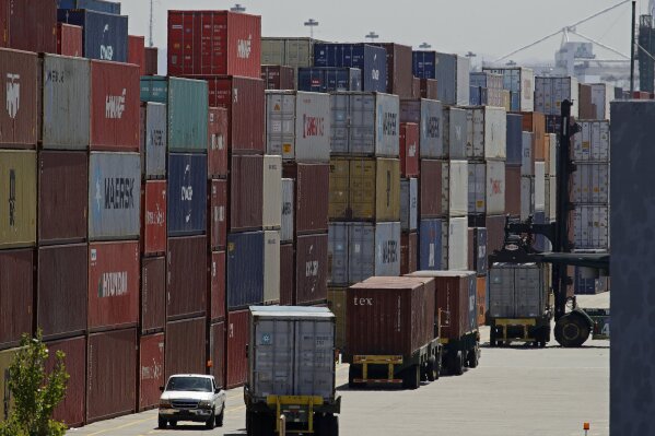 FILE - In this July 22, 2019, file stacked containers wait to be loaded on to trucks at the Port of Oakland in Oakland, Calif. China's government says trade negotiators are in “close communication” with Washington ahead of a weekend deadline for a U.S. tariff hike. But a Ministry of Commerce spokesman gave no indication of possible progress in trade talks or whether Washington might postpone the increase. (AP Photo/Ben Margot, File)