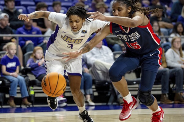 FILE - James Madison guard Hevynne Bristow (3) and Stony Brook guard Shamarla King (15) chase down the ball during the first half of an NCAA college basketball game in the first round of the WBIT in Harrisonburg, Va., Thursday, March 21, 2024. The surging interest in women's college basketball prompted the NCAA to double down on its investment last summer by backing the inaugural Women's Basketball Invitation Tournament. (Daniel Lin/Daily News-Record via AP, File)