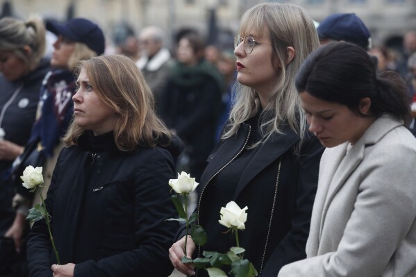 People pay tributes to French teacher Dominique Bernard during his funeral, in Arras, northern France, Thursday, Oct. 19, 2023. Bernard, 57, was stabbed to death at the school by a suspected Islamist extremist. (AP Photo/Michel Spingler)