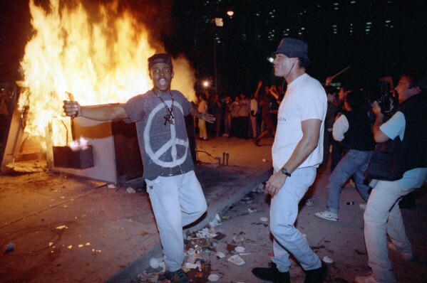 In this April 29, 1992 file photo, demonstrators protest the verdict in the Rodney King beating case in front of the Los Angeles Police Department headquarters in Los Angeles. (AP Photo/Nick Ut, File)