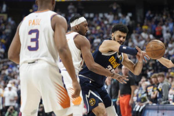 Denver Nuggets guard Jamal Murray, right, loses control of the ball as Phoenix Suns forward Josh Okogie, center, and guard Chris Paul defend in the first half of Game 2 of an NBA second-round playoff series Monday, May 1, 2023, in Denver. (AP Photo/David Zalubowski)