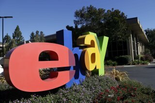 FILE - In this Oct. 17, 2012, file photo, an eBay sign sits in front of the company's headquarters in San Jose, Calif. On Wednesday, Sept. 23, 2020, federal prosecutors said four former eBay Inc. employees had agreed to plead guilty to their roles in a campaign of intimidation that included sending live spiders and cockroaches to the home of a Massachusetts couple who ran an online newsletter highly critical of the auction site. (AP Photo/Marcio Jose Sanchez, File)