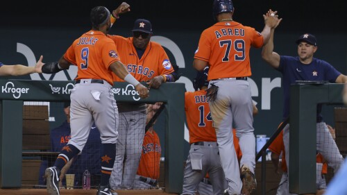 Houston Astros Corey Julks, left, and José Abreu, right, celebrate scoring on a triple from Chas McCormick in the eighth inning of a baseball game against the Texas Rangers, Sunday, July 2, 2023, in Arlington, Texas. (AP Photo/Gareth Patterson)