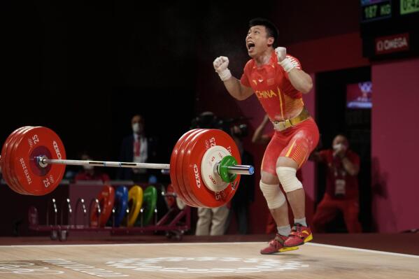 Chen Lijun of China celebrates after winning the gold medal and setting an Olympic record in the men's 67kg weightlifting event, at the 2020 Summer Olympics, Sunday, July 25, 2021, in Tokyo, Japan. (AP Photo/Luca Bruno)