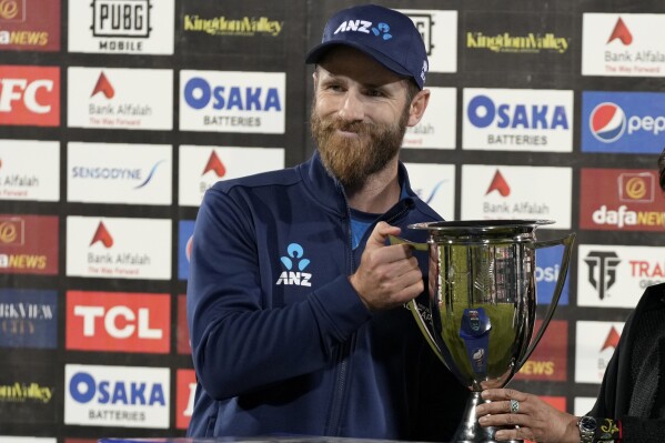 FILE - New Zealand's Kane Williamson receives ODI series trophy after winning the 3rd one-day international cricket match and ODI series against Pakistan, in Karachi, Pakistan, on Jan. 13, 2023. New Zealand will consider naming captain Kane Williamson in its squad for the ICC World Cup in October in India even if he will miss early games while recovering from a knee injury. (AP Photo/Fareed Khan, File)
