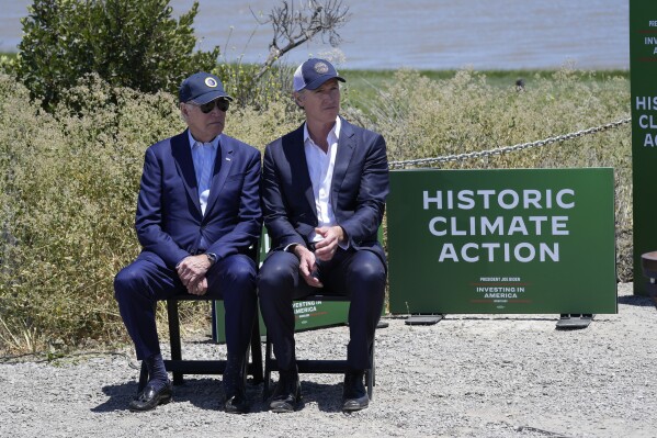 FILE – President Joe Biden sits with California Gov. Gavin Newsom while they listen to speakers at the Lucy Evans Baylands Nature Interpretive Center and Preserve in Palo Alto, California, on Monday, June 19, 2023. Newsom has pursued an aggressive climate policy as governor, including committing to spend tens of billions of dollars over the next few years on environmental projects and programs. But his proposals have been met with criticism by some environmental groups, who say they don't do enough to protect the state's threatened species and fragile ecosystems. (AP Photo/Susan Walsh, File)