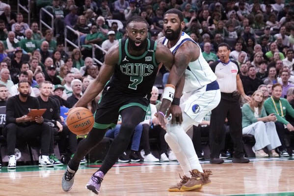 Boston Celtics guard Jaylen Brown (7) drives to the basket past Dallas Mavericks guard Kyrie Irving during the first half of Game 2 of the NBA Finals basketball series, Sunday, June 9, 2024, in Boston. (AP Photo/Steven Senne)