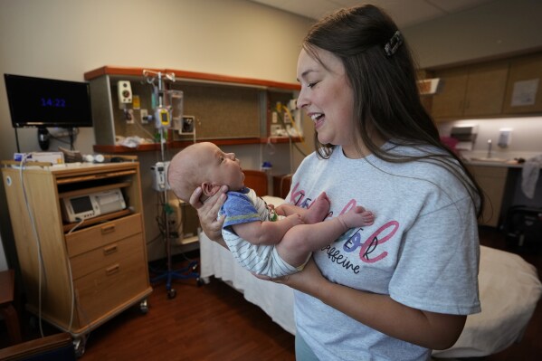 Katie O'Brien holds her son, Bennett, on Tuesday, Aug. 29, 2023, in the birthing room where she delivered him in July at the Henry County Medical Center in Paris, Tenn. The maternity ward at the hospital closed in early September. "It's a horrible thing for our community," says O'Brien. "Any young person looking to move here won't want to come. Why would you want to come somewhere where you can't have a baby safely?" (AP Photo/Mark Humphrey)