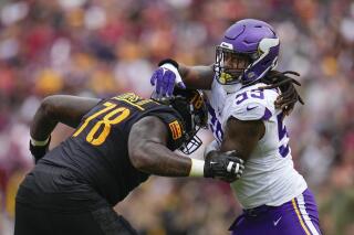 FILE - Washington Commanders offensive tackle Cornelius Lucas (78) attempts to hold off Minnesota Vikings linebacker Za'Darius Smith (55) during the first half of an NFL football game, Sunday, Nov. 6, 2022, in Landover, Md. The Cleveland Browns have agreed to acquire three-time Pro Bowl pass rusher Za'Darius Smith in a trade from the Minnesota Vikings, a person familiar with the deal told the Associated Press on Friday night, May 12, 2023. (AP Photo/Julio Cortez, File)