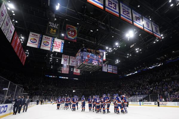 The New York Islanders head coach Barry Trotz, left, leaves the ice as his team celebrates after Game 4 of an NHL hockey Stanley Cup first-round playoff series against the Pittsburgh Penguins, Saturday, May 22, 2021, in Uniondale, N.Y. The Islanders won 4-1. (AP Photo/Frank Franklin II)