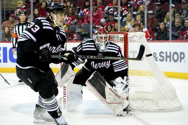 New Jersey Devils goaltender Vitek Vanecek (41) watches defenseman Ryan Graves (33) hit the puck during the second period of an NHL hockey game against the Colorado Avalanche, Friday, Oct. 28, 2022, in Newark, N.J. (AP Photo/Julia Nikhinson)