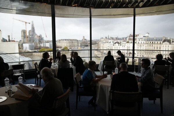 Clients sit at tables at La Tour d'Argent restaurant in Paris, Wednesday, Dec. 13, 2023. (AP Photo/Christophe Ena)