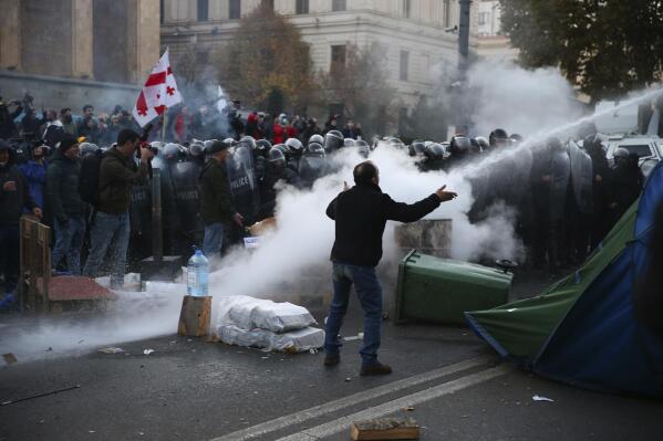 Police use a water cannon against demonstrators gathered at the Georgian parliament building in Tbilisi, Georgia, Monday, Nov. 18, 2019.Police in riot gear in the country of Georgia are trying to push thousands of demonstrators away from the parliament building in the capital on the second day of sizable protests over the failure of promised election reforms. (AP Photo/Zurab Tsertsvadze)