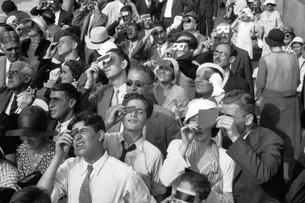 FILE - Eclipse watchers squint through protective filters as they view an eclipse of the sun from the top deck of New York's Empire State Building in New York on Wednesday, Aug. 31, 1932. Full solar eclipses occur every year or two or three, often in the middle of nowhere like the South Pacific or Antarctic. (AP Photo/File, File)