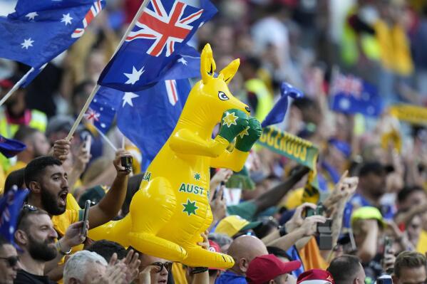 Aficionados australianos celebran su victoria en el partido del Grupo D del Mundial que enfrentó a Túnez y Australia, en el estadio Al Janoub, en Al Wakrah, Qatar, el 26 de noviembre de 2022. (AP Foto/Luca Bruno)