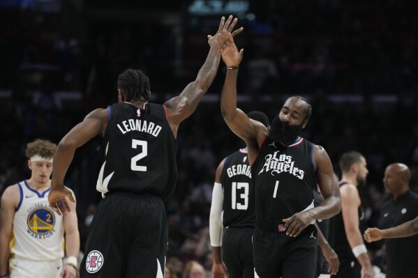 Los Angeles Clippers forward Kawhi Leonard (2) high-fives guard James Harden (1) during the second half of an NBA basketball game against the Golden State Warriors in Los Angeles, Saturday, Dec. 2, 2023. (AP Photo/Ashley Landis)