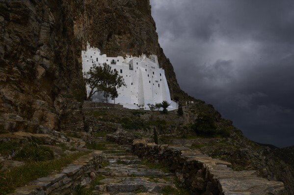 O Mosteiro de Panagia Hozoviotissa, esculpido em um penhasco bem acima do Mar Egeu, é iluminado pelo sol durante um dia nublado, na ilha de Amorgos, Grécia, no domingo, 30 de março de 2025. (Foto AP/Petros Giannakouris)