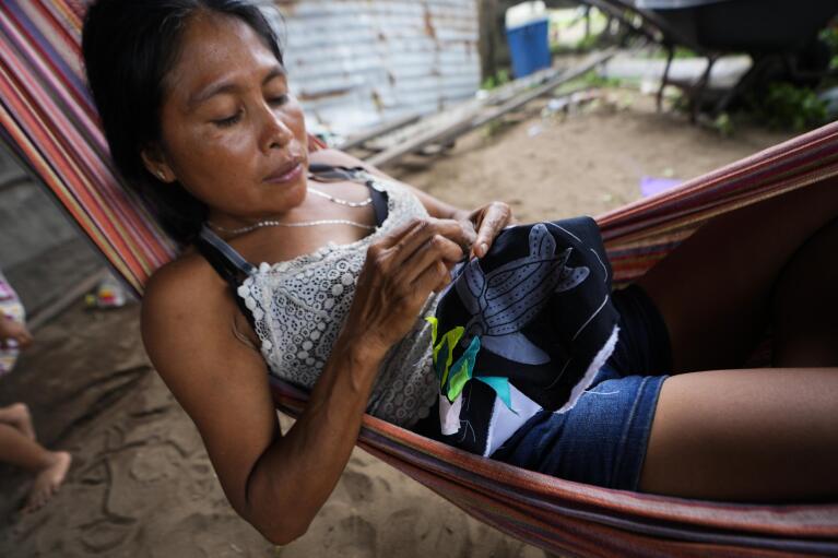 Desidelia Martinez, who is Guna Indigenous, sews a hand-made textile called Mola with a design of a turtle at her house in Armila, Panama, Saturday, May 20, 2023. Sea turtles in Panama now have the legal right to live in an environment free of pollution and other detrimental impacts caused by humans, a change that represents a different way of thinking about how to protect wildlife. (AP Photo/Arnulfo Franco)