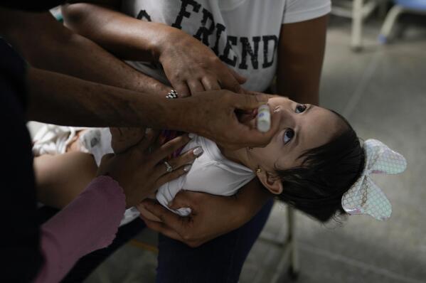 A toddler is inoculated for polio during a free vaccination campaign for polio, rubella and influenza organized by the Health Ministry in Caracas, Venezuela, Saturday, June 18, 2022. An Associated Press analysis of rare government data and estimates from public health agencies shows that Venezuela’s vaccination crisis is growing, putting it among the world’s worst countries for getting required shots that protect young children against potentially fatal diseases. (AP Photo/Ariana Cubillos)