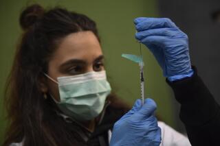 FILE - A medical staff member prepares a Pfizer vaccine during a COVID-19 vaccination campaign in Pamplona, northern Spain, on March 16, 2021. The European Medicines Agency said it has begun an accelerated review process for an experimental coronavirus vaccine booster made by the Spanish company Hipra. In a statement on Tuesday, the EU medicines regulator said its evaluation is based on preliminary data from laboratory studies and research in adults that compared Hipra’s booster shot to the vaccine made by Pfizer-BioNTech. (AP Photo/Alvaro Barrientos, File)