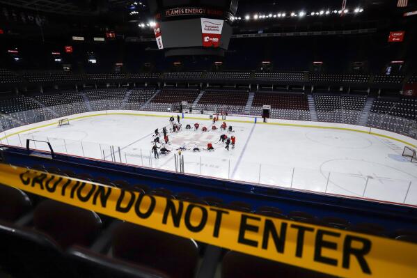 Calgary Flames' players take to the ice during NHL hockey practice in Calgary, Alberta, Monday, July 13, 2020. (Jeff McIntosh/The Canadian Press via AP)