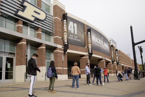 FILE - In this Oct. 14, 2020, file photo, voters line up outside Purdue University's Mackey Arena for early voting ahead of the 2020 general election, in West Lafayette, Ind. The NCAA announced Monday, Jan. 4, 2020, that this year's 67 men's basketball tournament games including the Final Four will be played entirely in Indiana.
Games will be played on two courts inside Lucas Oil Stadium as well as at Bankers Life Fieldhouse, Hinkle Fieldhouse, Indiana Farmers Coliseum, Mackey Arena at Purdue and Assembly Hall in Bloomington. (Nikos Frazier/Journal & Courier via AP, File)/