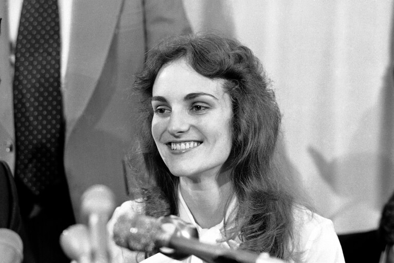 FILE- Patricia “Patty” Hearst smiles at a press conference in San Francisco, Nov. 19, 1976. The newspaper heiress was kidnapped at gunpoint on Feb. 4, 1974, by the Symbionese Liberation Army, a little-known armed revolutionary group. The 19-year-old college student's infamous abduction in Berkeley, Cali., led to Hearst joining forces with her captors for a 1974 bank robbery that earned her a prison sentence. Hearst, granddaughter of wealthy newspaper magnate William Randolph Hearst, will turn 70 on Feb. 20. (AP Photo/File)