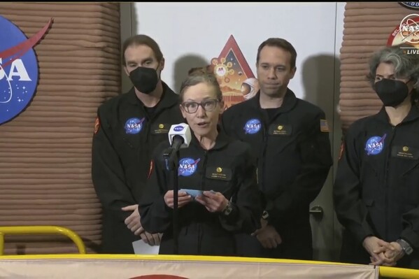 In this image made from video provided by NASA, Kelly Haston, a crew member of the first CHAPEA mission, speaks in front of other members, from left to right, Ross Brockwell, Nathan Jones, and Anca Selariu, Saturday, July 6, 2024, at Johnson Space Center in Houston, Texas. The crew of a NASA mission to Mars emerged from their craft after a yearlong voyage that never left Earth. The four volunteers crew members spent more than 12 months inside NASA's first simulated Mars environment at Johnson Space Center in Houston, coming out of the artificial alien environment Saturday. (NASA via AP)