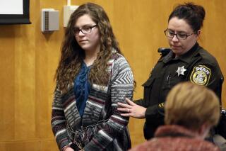 FILE - In this Dec. 21, 2017, file photo, Anissa Weier, one of two Wisconsin girls who tried to kill a classmate to win favor with a fictional horror character named Slender Man, is led into Court for her sentencing hearing, in Waukesha, Wis. Weier, is scheduled to appear Wednesday, March 10, 20201, before the Waukesha County Circuit Court judge who earlier sentenced her to 25 years in a mental health institution and ask for her conditional release. (Michael Sears/Milwaukee Journal-Sentinel via AP, File)