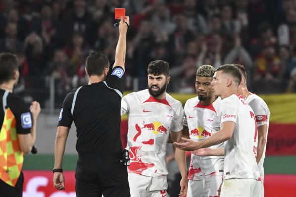 Referee Sven Jablonski shows the red card to Leipzig's Josko Gvardio, center, during the German Soccer Cup semifinal match between SC Freiburg and RB Leipzig in Freiburg, Germany, Tuesday, May 2, 2023. (Marijan Murat/dpa via AP)