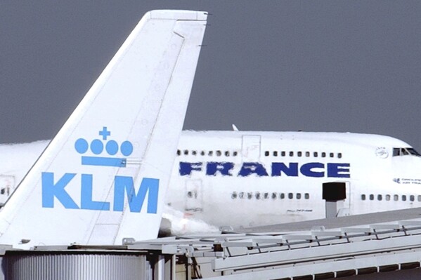 FILE - An Air France jumbo jet rolls behind the tail of a KLM Royal Dutch airliner at Charles de Gaulle airport in Roissy, north of Paris. On Sept. 30, 2003. Low-cost carriers Ryanair and Malta Air won a European court case Wednesday Dec.20 2023 against the EU's decision to approve billions of euros of state aid by the French government to holding company Air France-KLM during the COVID-19 pandemic. (AP Photo/Remy de la Mauviniere, File)