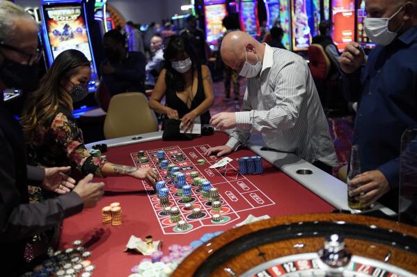 FILE - People play roulette at the Mohegan Sun Casino at Virgin Hotels Las Vegas on March 25, 2021, in Las Vegas. Nevada casinos continued a hot streak in December, tallying a 10th straight month of $1 billion or more in house winnings and propelling end-of-year figures to a record $13.4 billion. A Nevada Gaming Control Board report released Thursday, Jan. 27, 2022, provided more evidence that gambling recovered last year after coronavirus closures in 2020. (AP Photo/John Locher, File)