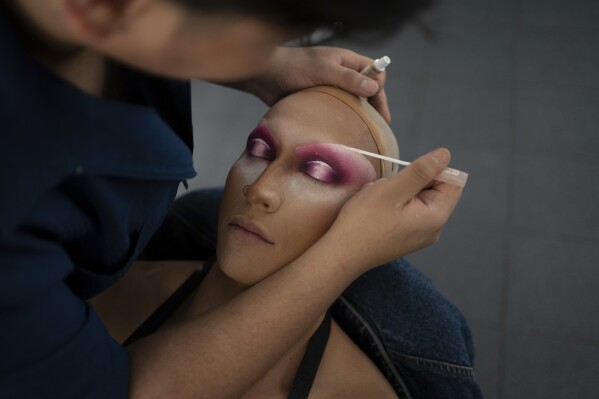 A makeup-artist builds drag eyes on news anchor Guillermo Barraza as he is transformed into his drag character Amanda in preparation for the pre-taping of his program 