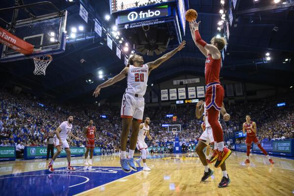 Kansas guard Gradey Dick, right, goes up for a shot against Texas Tech guard Jaylon Tyson (20) during the first half of an NCAA college basketball game in Lawrence, Kan., Tuesday, Feb. 28, 2023. (AP Photo/Reed Hoffmann)